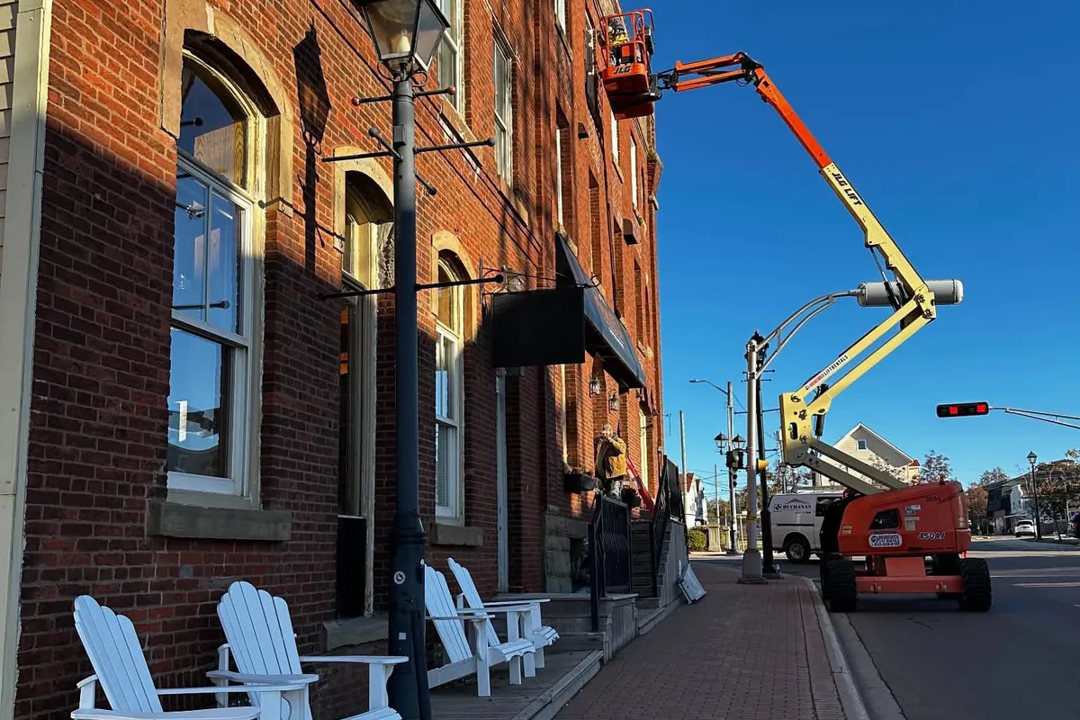 Harbour Terrace on Queen Street in Summerside, seen from the brick sidewalk with a boom lift at work on the building